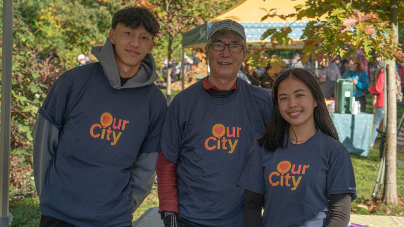 group of people with "Our City" shirts