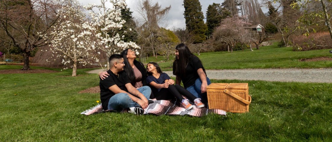 family laughing while enjoying a picnic