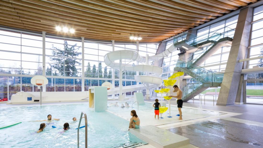 A white water slide indoors with children playing