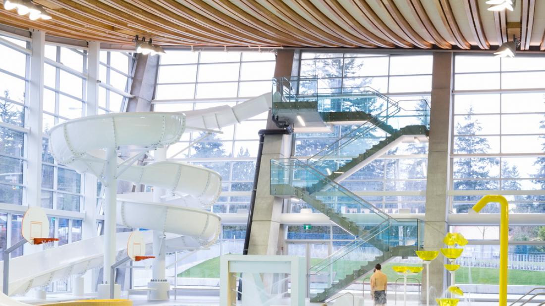 A white water slide with yellow accents indoors