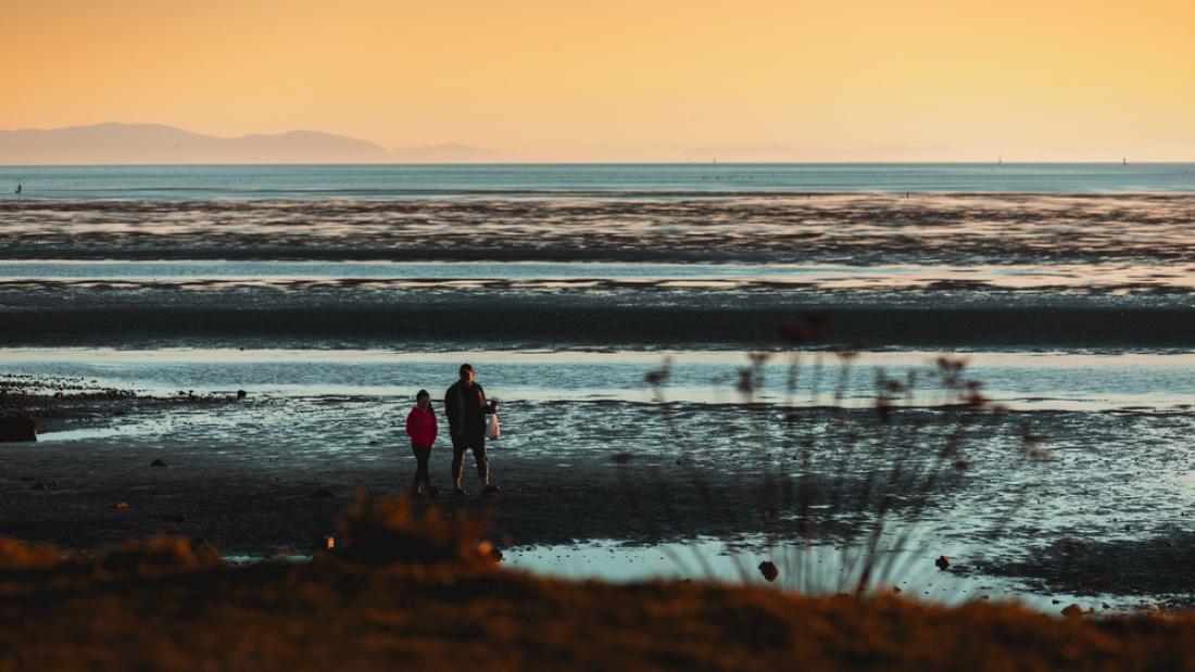 Two people on the beach when the tide is out 
