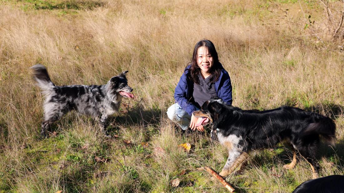 Two dogs and a woman at off-leash area