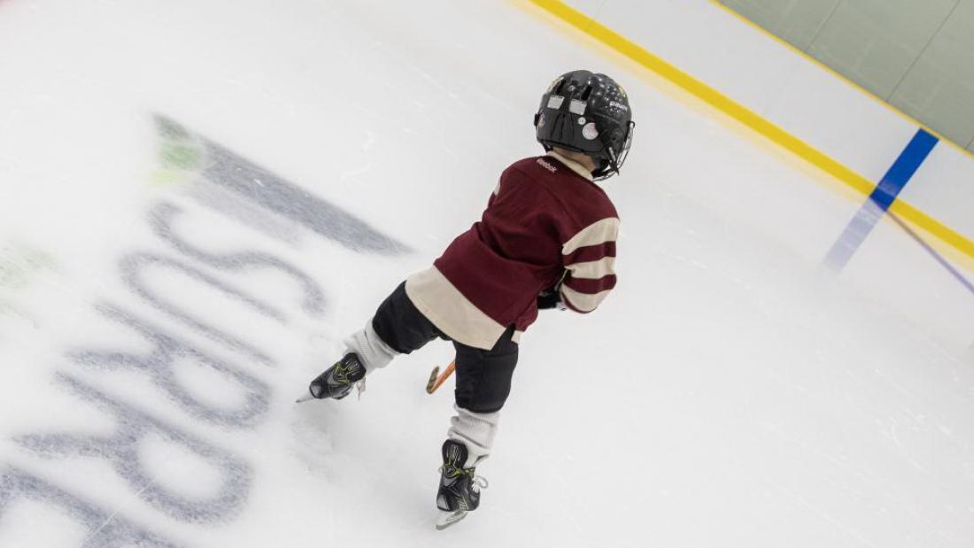 Boy playing hockey at the arena.