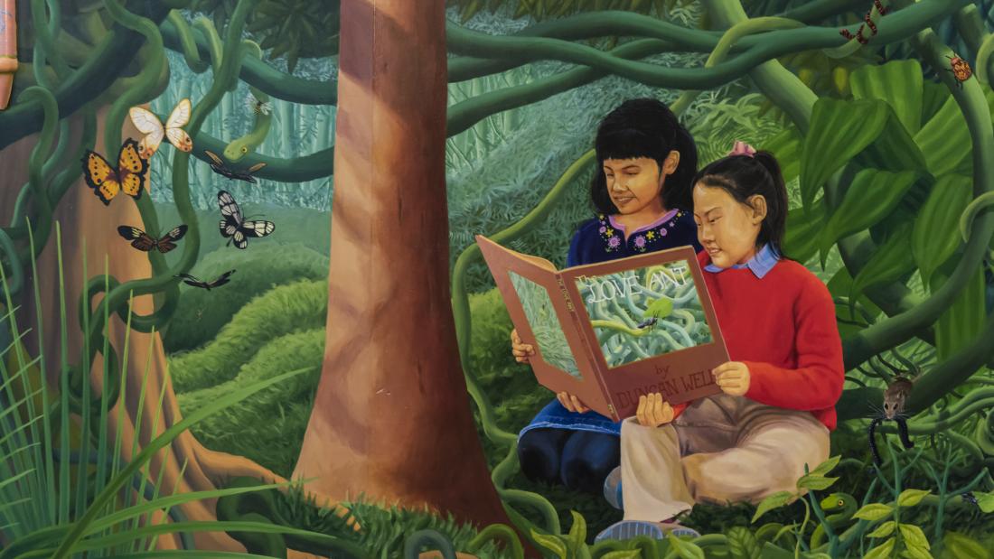 Detail of kids reading in the jungle