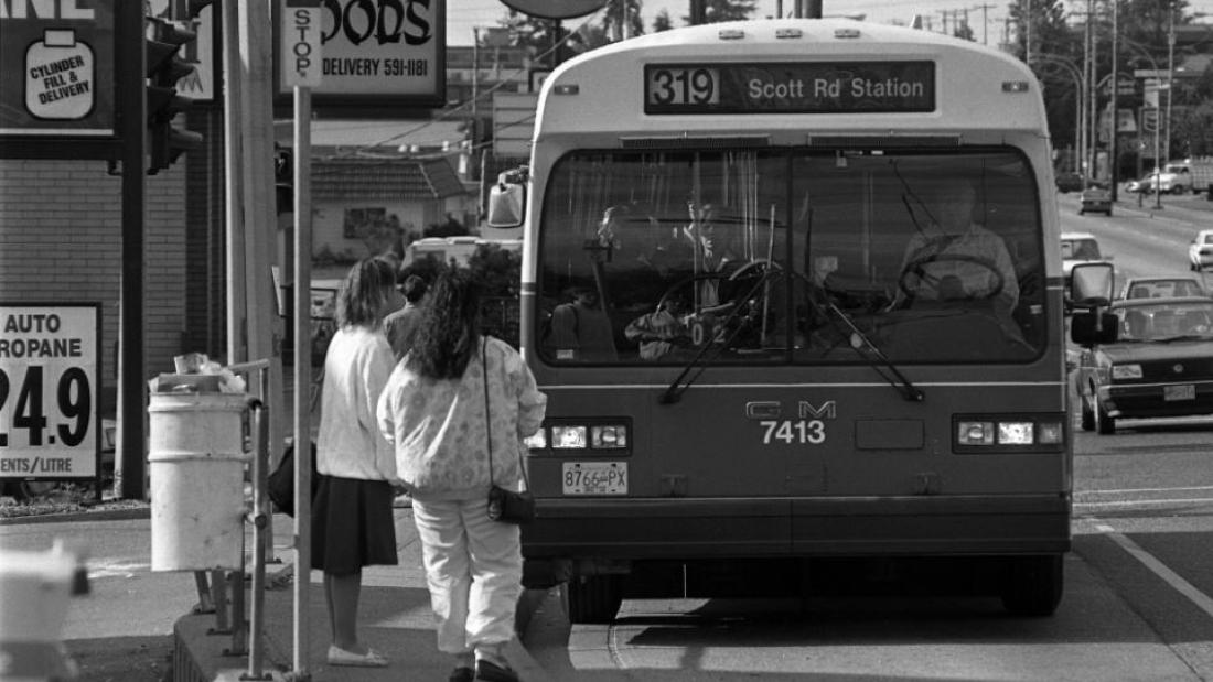 Passengers boarding B.C. Transit bus on Scott Road, 1993. Surrey Leader Photograph Collection, 2017.0022.93-493.2. Note: Photograph appears to have been taken just past north east corner of 86 Avenue and 120 Street. DQ and Chevron are still in same location