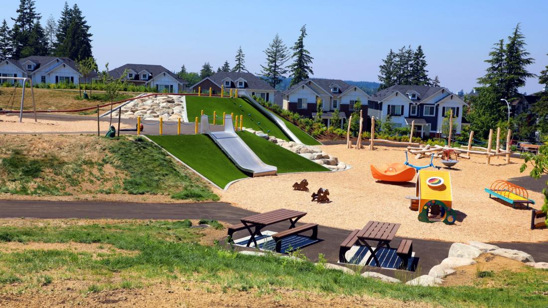 A sloped park playground with large metal slides