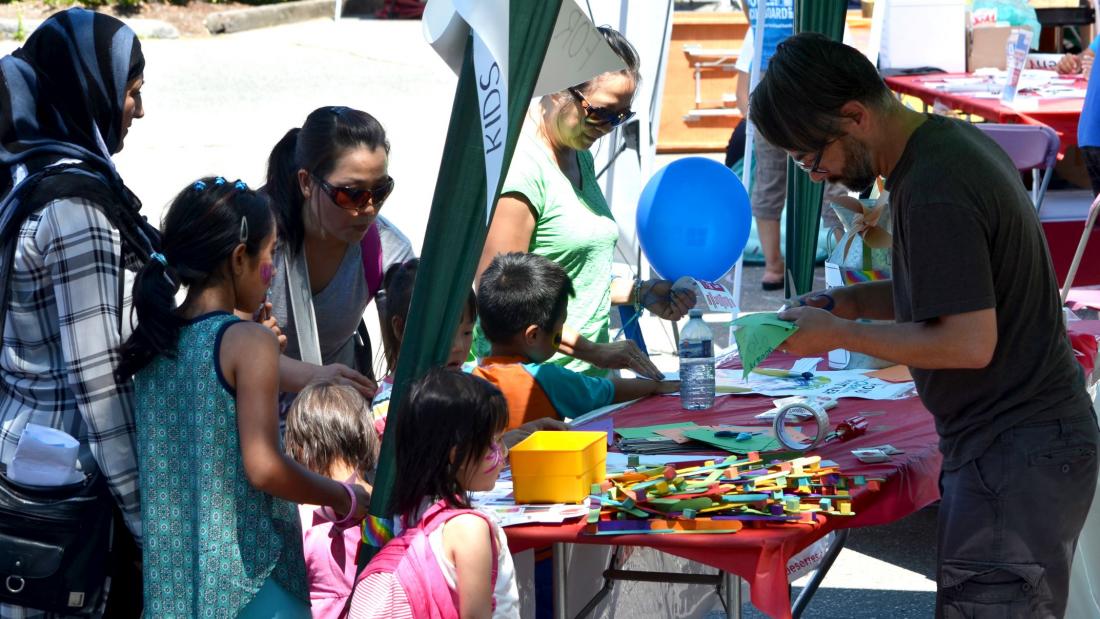 Children at a craft booth at an outdoor festival