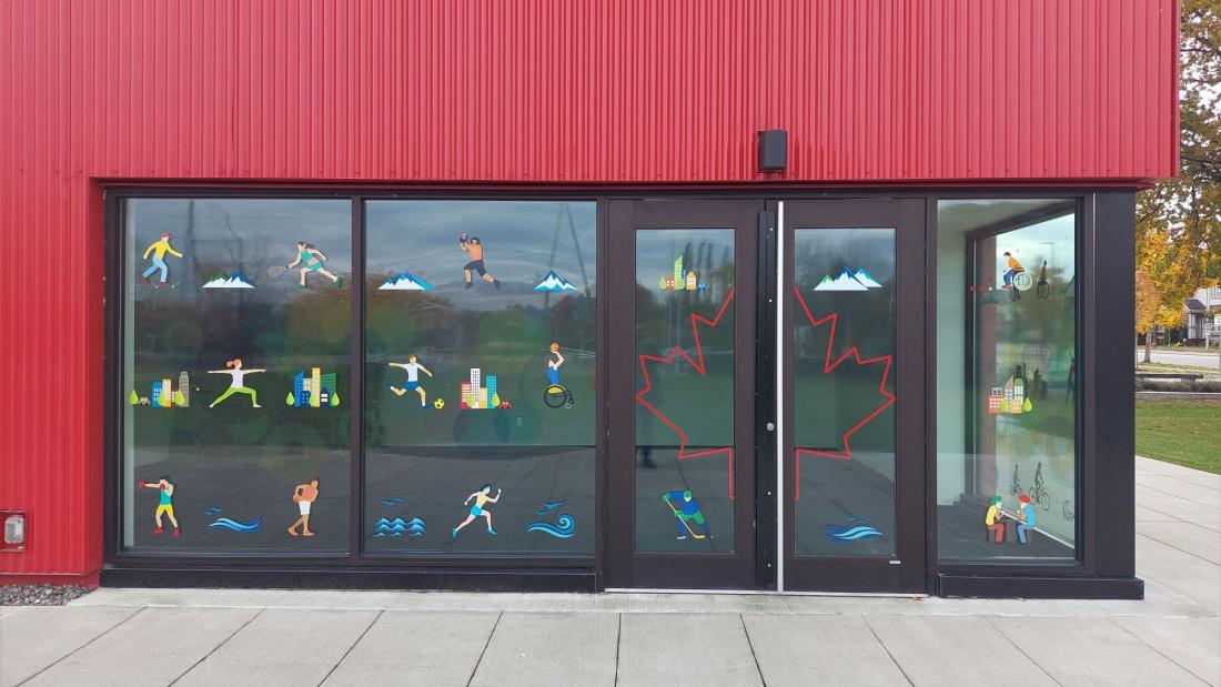 Cartoon decals on a window of a red building at a park