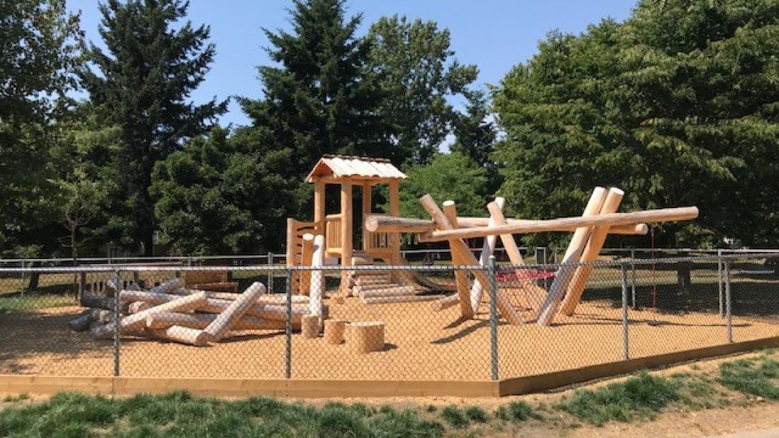 Wooden play structures behind a fence