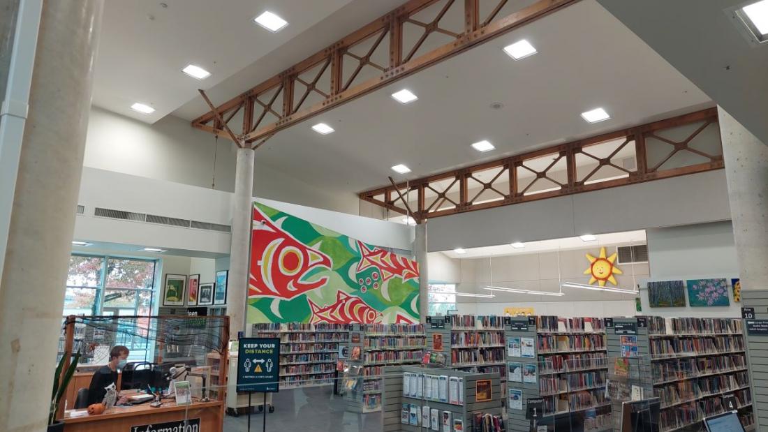 Green and red Indigenous fish mural on a library wall