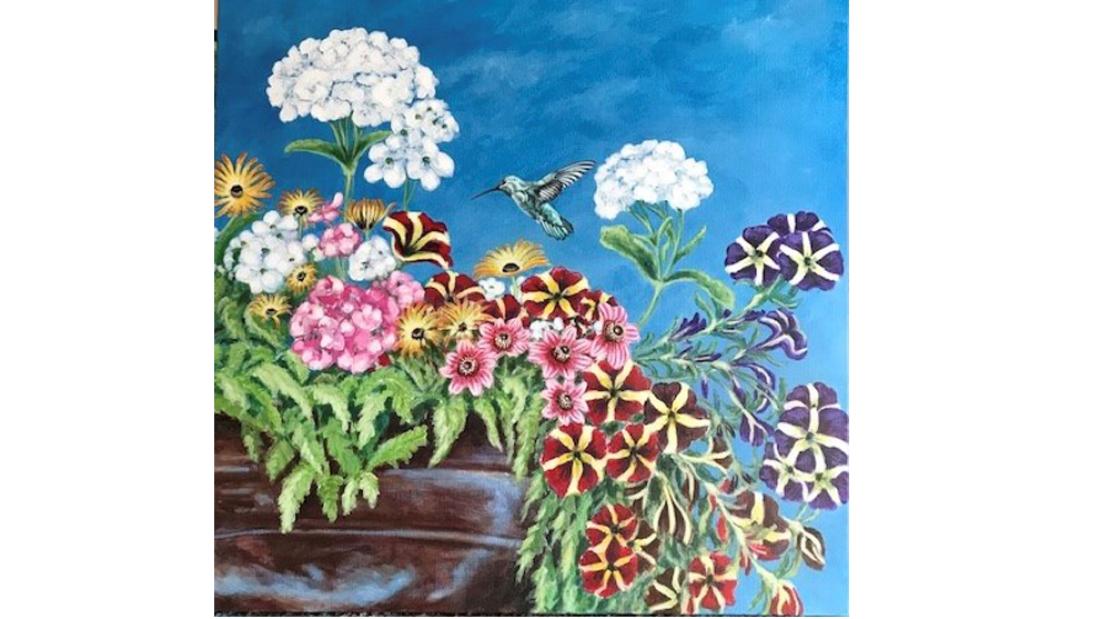 A colourful painting of flowers and a hummingbird in the centre.