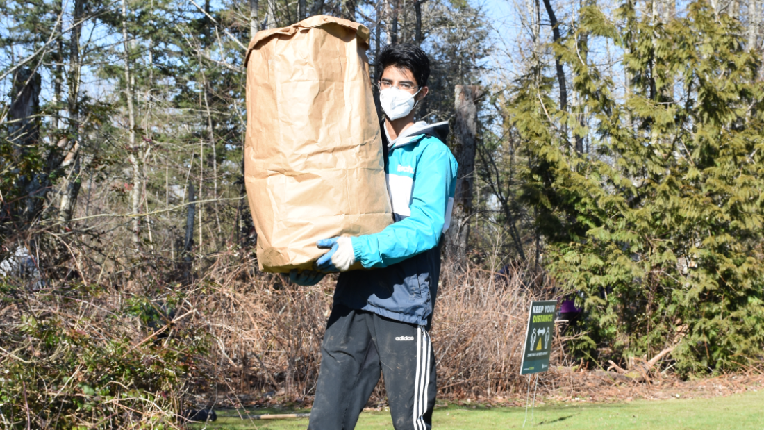 volunteer carrying bag of plants