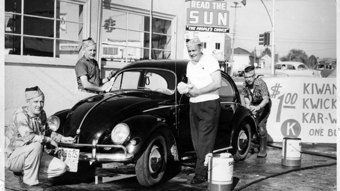 black and white photo of several men washing a car. Kiwanis Car Wash, ca. 1950s.