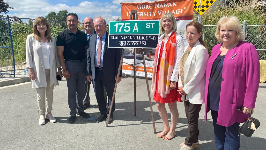 Mayor & Council standing with a commemorative street sign: A ‘Guru Nanak Village Way’ sign