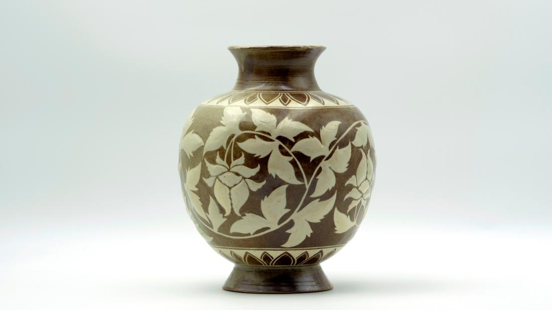 Brown ceramic vase with grey peonies on it.