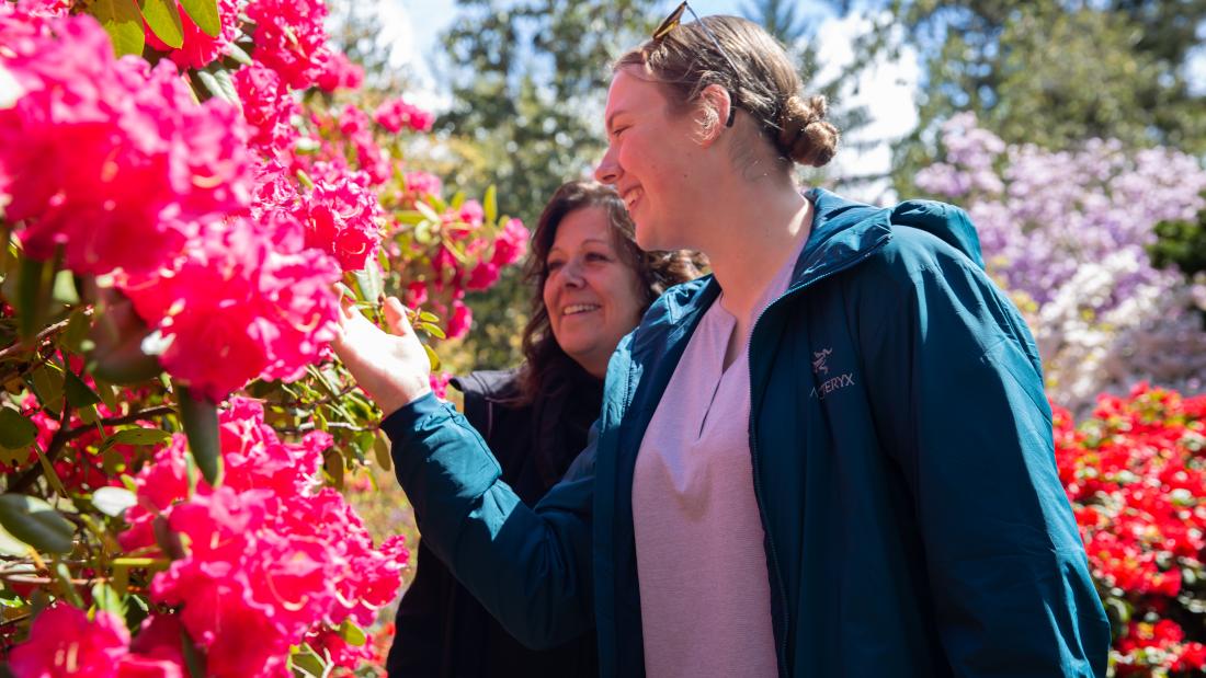 Mother and daughter looking at a rhododendron.