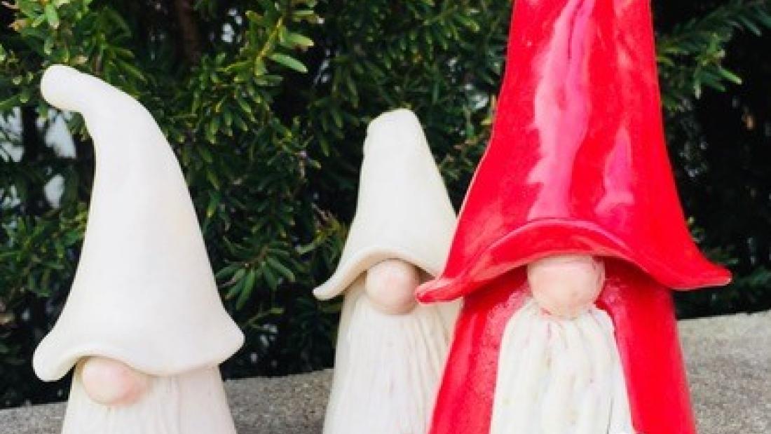ceramic gnomes with big pointy hats. one is red and two are white.