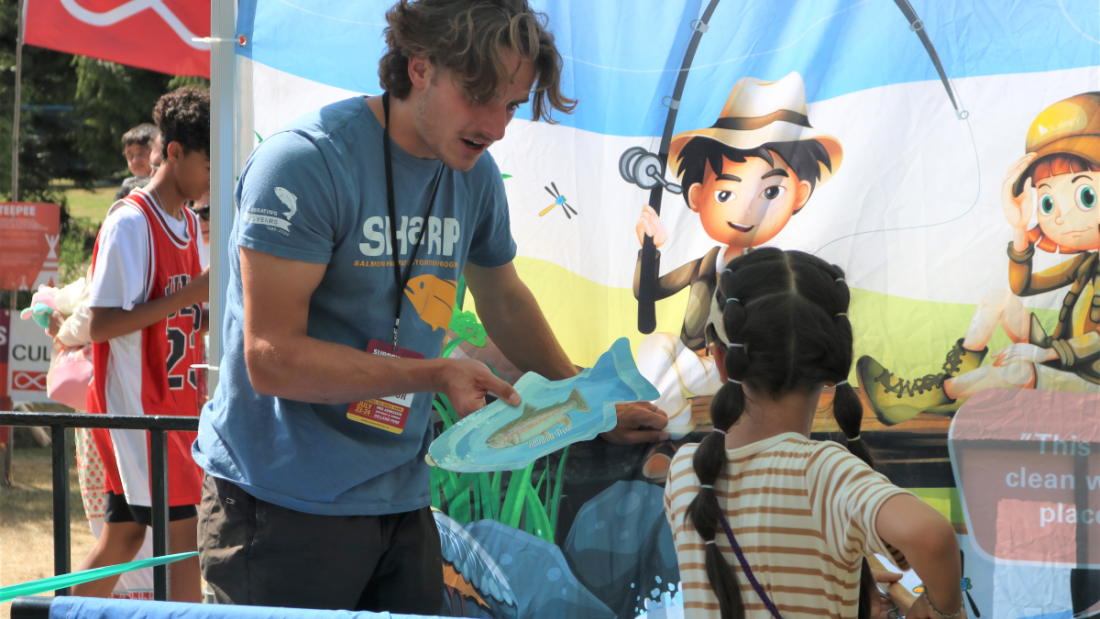 a sharp member showing a child a salmon illustration