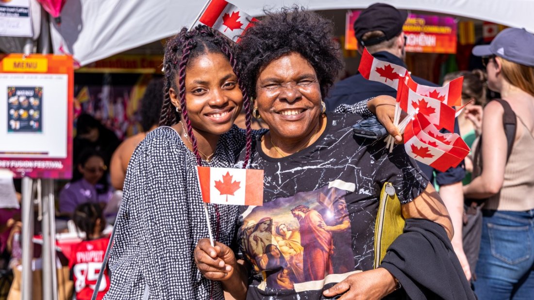 two people smiling with canadian flag