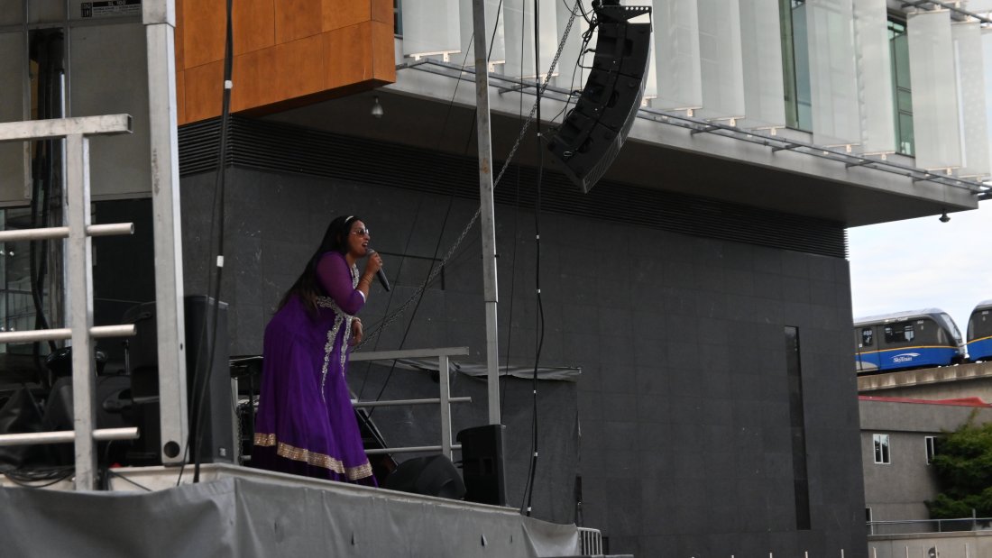 Karima Essa onstage speaking into a microphone