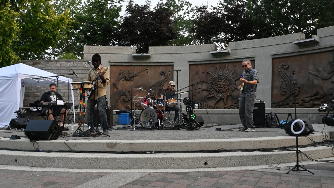 Four piece band plays on an outdoor stage at Holland Park