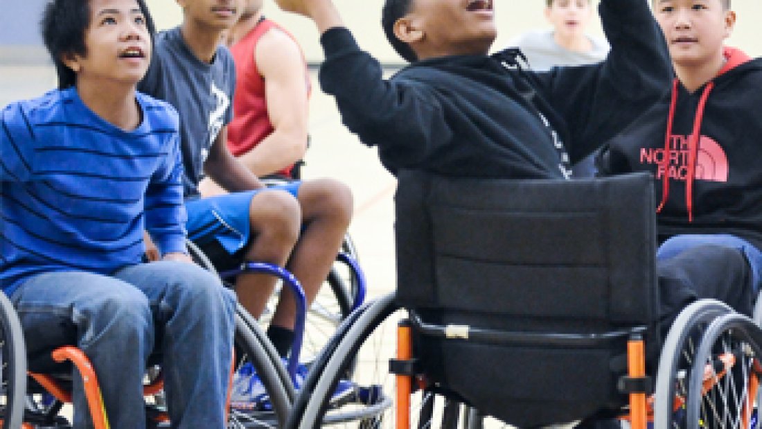 5 youth playing wheelchair basketball.