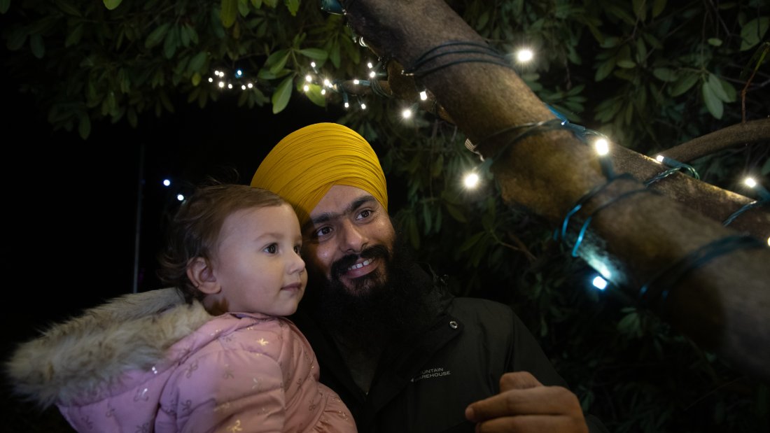 father and daughter admire lights in tree
