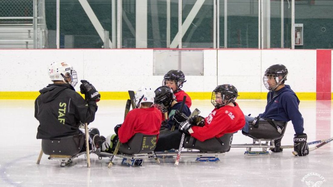 5 youth participating in Para Ice hockey at an Arena.