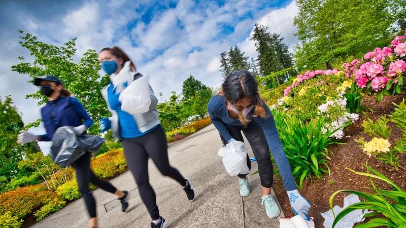 Three women in a park picking up litter