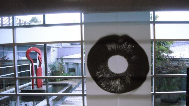 A black circular drawing in front of a window