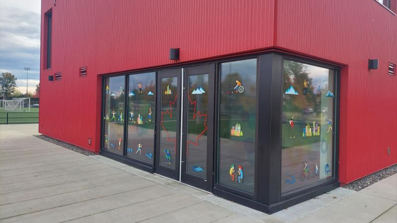 Cartoon decals on a window of a red building at a park