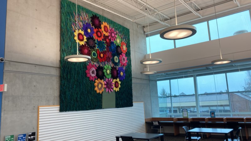Photo of Flower Power by Sola Fiedler: Colourful tapestry depicting 3D flowers made from repurposed and recycled materials