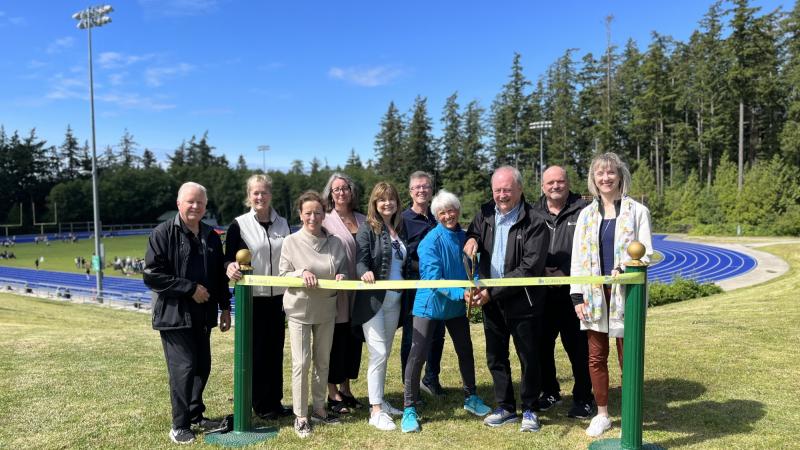 Mayor & Council and community members cut a ribbon in front of walking track