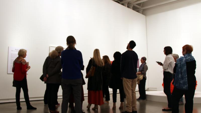 Visitors gather around an artwork during a tour at Surrey Art Gallery