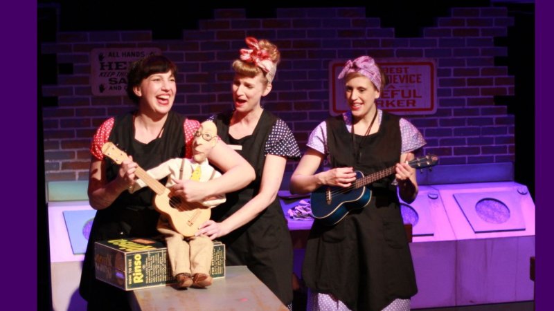 Two performers in Somebody Loves You, Mr. Hatch on stage holding puppet, Mr. Hatch. The other performer plays the ukulele
