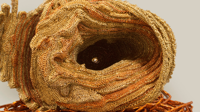 A hole at the center of a sea shell made out of crochet and recycled material