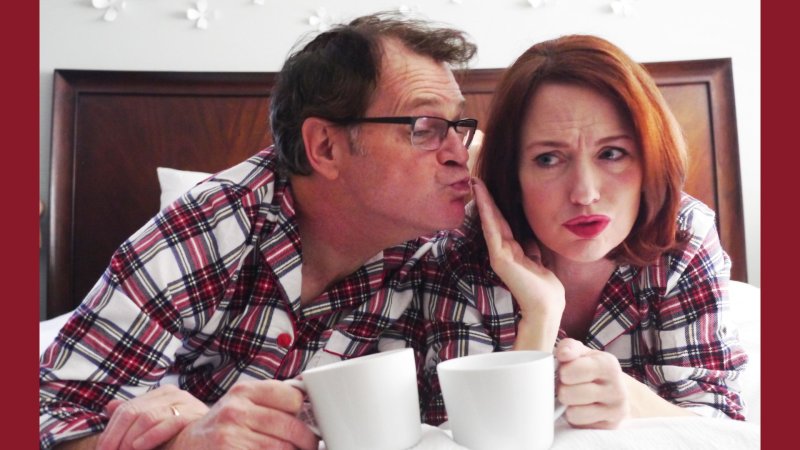 A couple in plaid red pajamas drinking tea.
