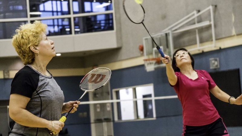 Two women playing badminton.
