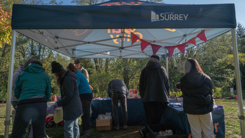 people in a City of Surrey tent organising things