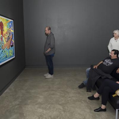 Visitors looking at a colourful painting 