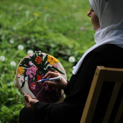 Image of PICS cultural exchange project participant Safaa embroidering