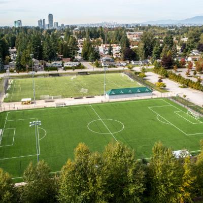Aerial view of two athletic fields with cityscape in the background