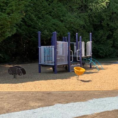 Purple playground with a gravel walking path beside it