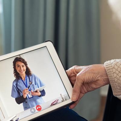 woman holding tablet, doctor appears on tablet