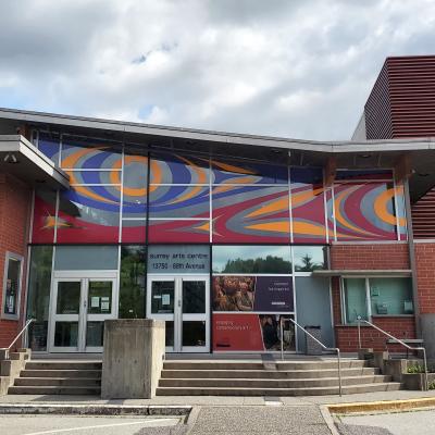 A photo of Surrey Arts Centre with a mural on its front windows.