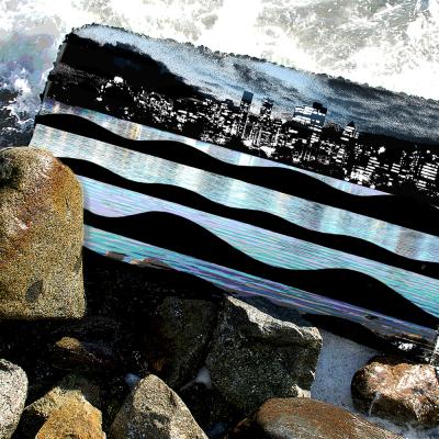 Mixed media artwork of rocks splashed by waves, a cellphone case lying on rocks with a cityscape image on it