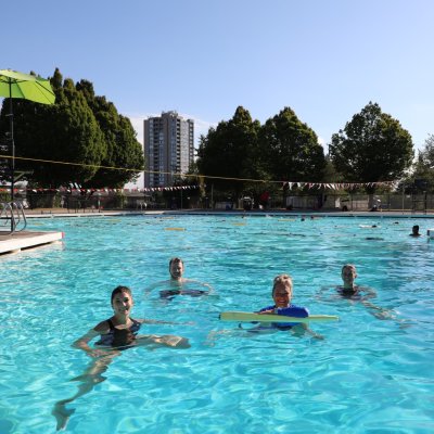 An outdoor pool with people swimming.