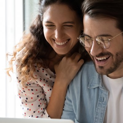Two people smiling at a computer.