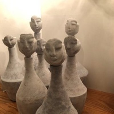 little statues with faces and oblong jug-like bodies