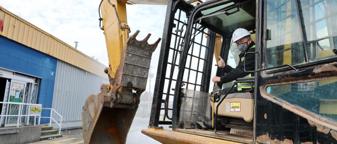 Mayor gives a thumbs up while driving an excavator